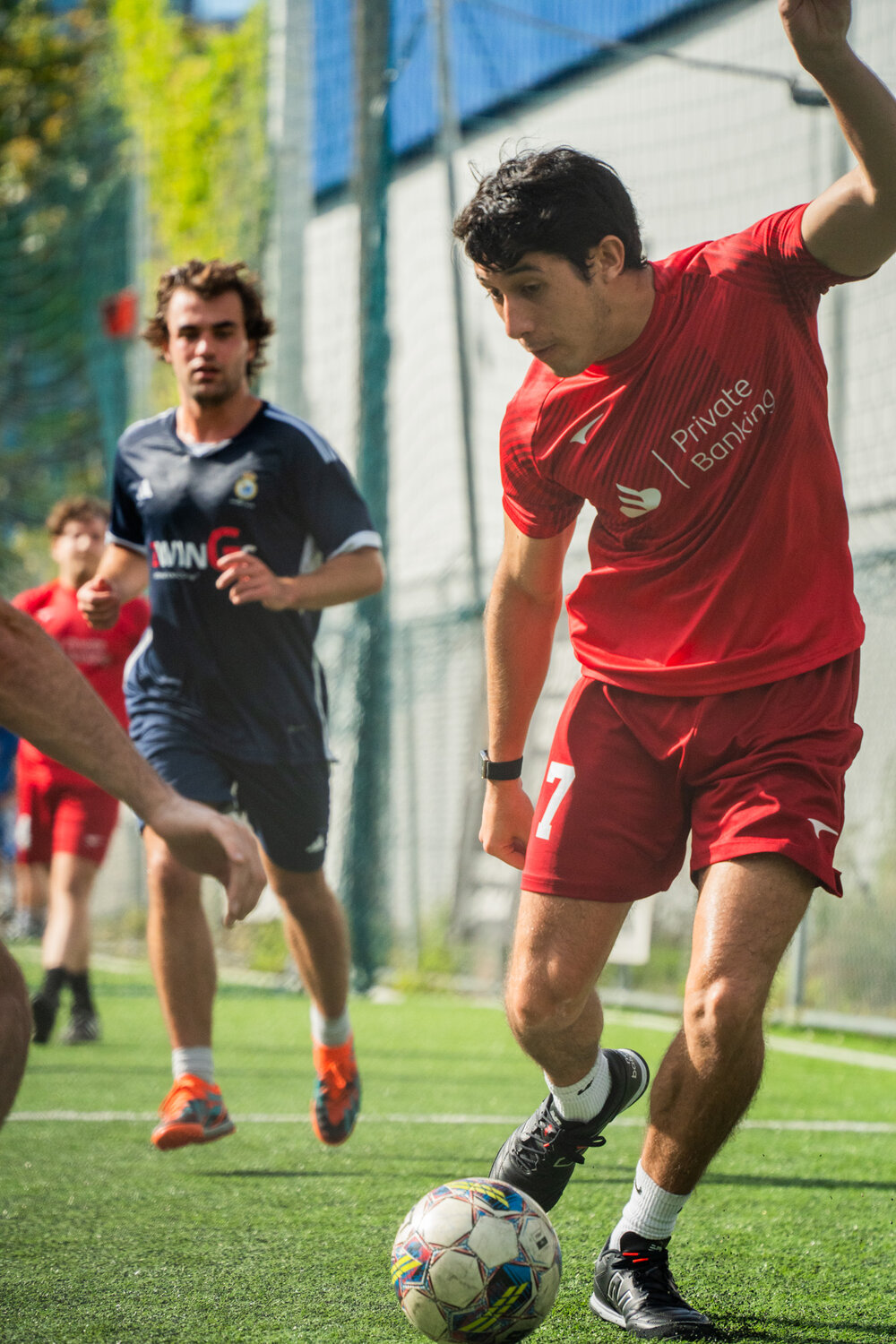 Captain in Private Banking kit, mid-action with the ball